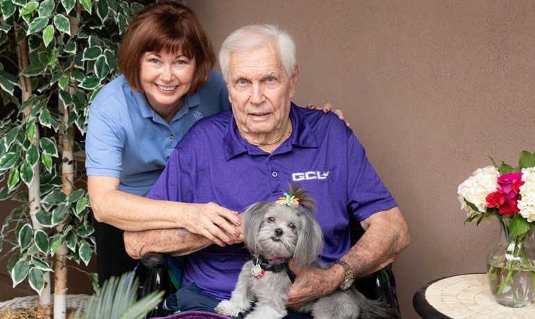Pet therapy volunteer with patient holding therapy dog