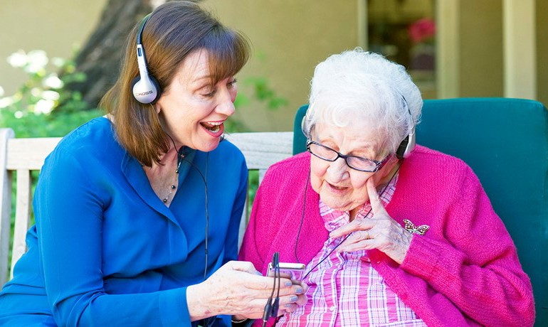 Maribeth Gallagher, DNP with patient listening to music