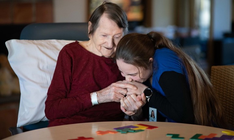 HOV staff member with patient at table with bright colored puzzle pieces