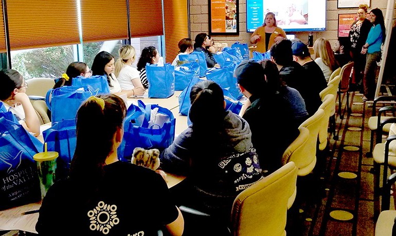 Birt's Bistro staff seated at long table with presenter at front