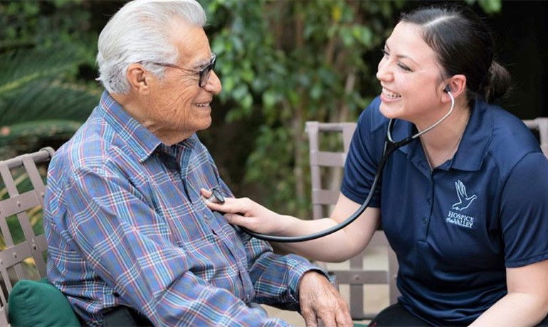 HOV staff member checks patient's heart with stethoscope