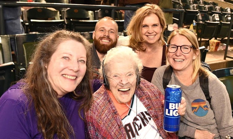Myra Blaker smiles with HOV caregivers and family members at the game
