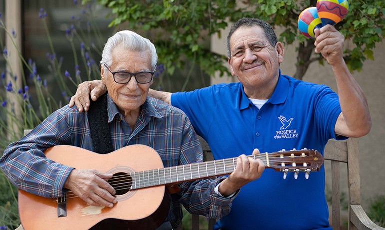 Guadalupe Villegas Avina and patient Feliciano playing guitar