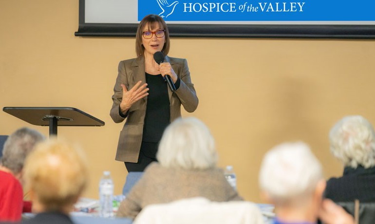 Maribeth Gallagher in front of audience with microphone