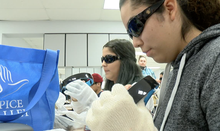 Students wearing sunglasses and gloves put on headphones