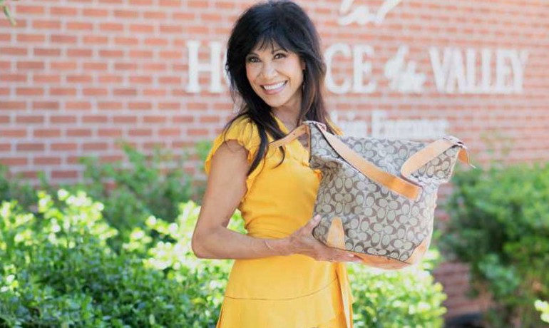Lin Sue Cooney holding up a purse