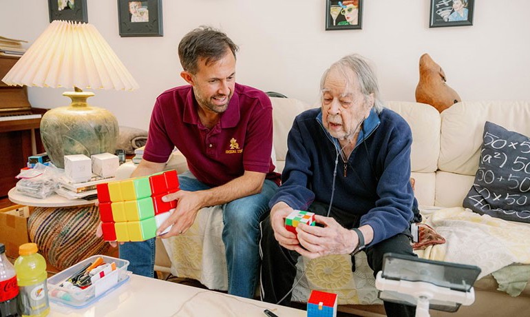 Math professor JW Gaberdiel and Dr. Evar Nering hold and discuss Rubik's Cubes